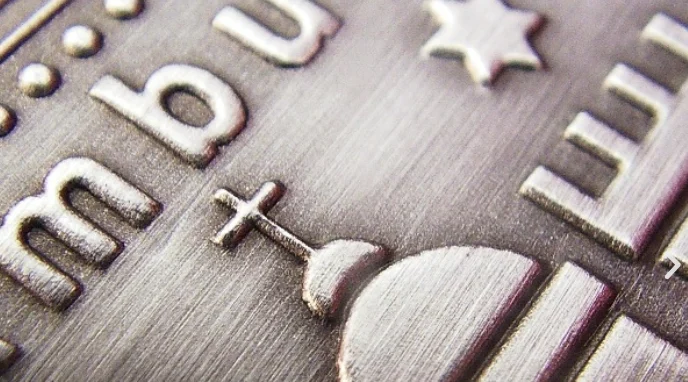 Makroaufnahme: geprägte Schrift und Relief auf gebürstetem Metalletikett